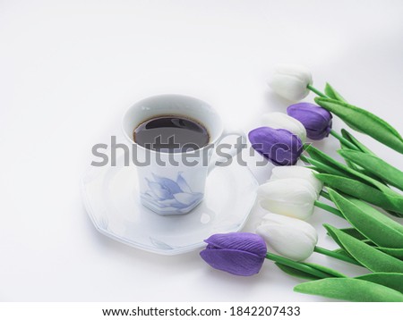 Purple and white tulips  Put on a white background  with A cup of hot coffee.