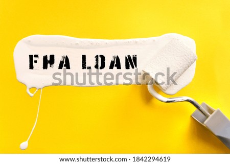 Business and finance concept. On a yellow background, the surface is painted white with a brush, on which it is written FHA LOAN