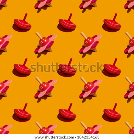 Seamless pattern with spinning tops on yellow background.