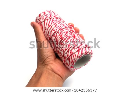 hand hold Red white rope roll. Packing cardboard box equipment.