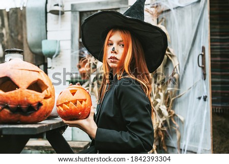 a girl in a witch costume having fun at a Halloween party on the decorated porch