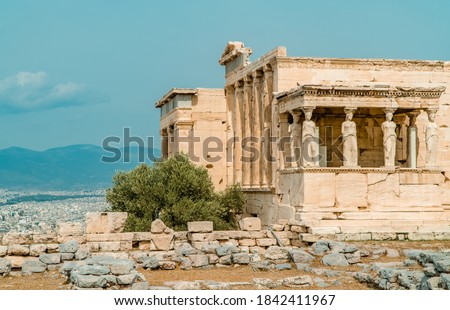 Caryatides, Erechtheion Temple at the Acropolis of Athens with a city view of Athens, Greece in the background
