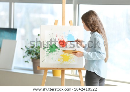 Cute girl painting at school