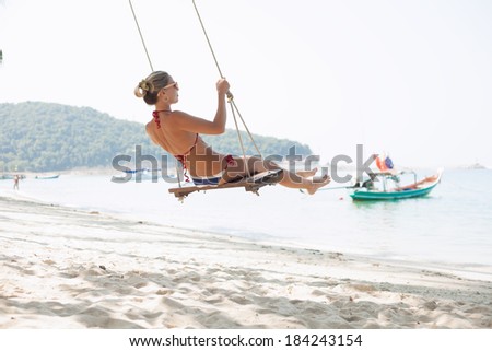 Girl on a swing on a beach. Outdoors