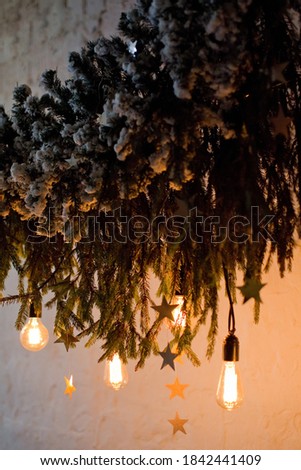 Christmas tree branches with snow and light bulbs