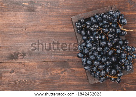 Fresh Dark blue purple grape in wooden box isolated on white background. Wine grapes, table grapes. Exotic fruit. Top view