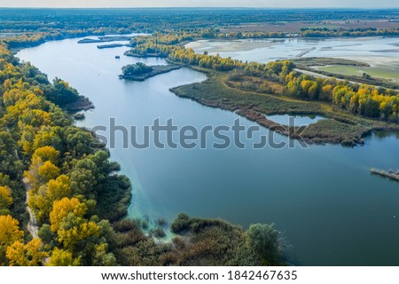 Aerial Flying over countryside, many lakes of fish farm, far big river under amazing cloudy sky in autumn time. Wonderful drone photo for ecological concept