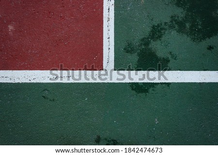 Top view of volleyball or tennis court. White lines and red and green ground. Sport field ground background.