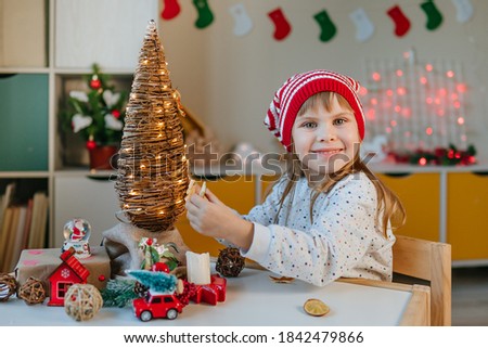 Little girl in gnome hat decorated vine Christmas tree