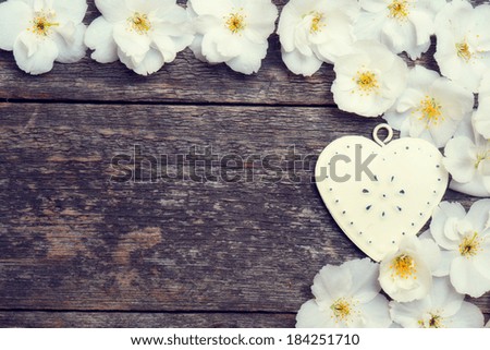 white flowers and heart on the wooden background