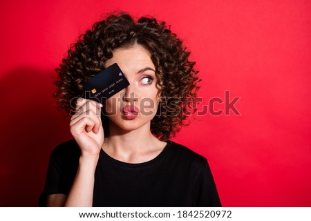 Photo of shiny tricky wavy lady dressed casual black outfit close eye credit card looking empty space lips pouted isolated red color background