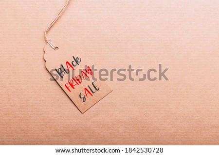 Words Black Friday Sale written on tags. Brown Kraft Paper Gift Tags on recycled brown paper as background, zero waste and sustainable living, shopping sale concept