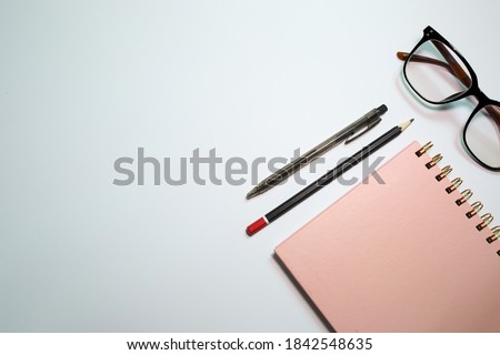Business concept. Top view of magnifying glass, pen, pencil, notebook and glasses isolated on a white background
