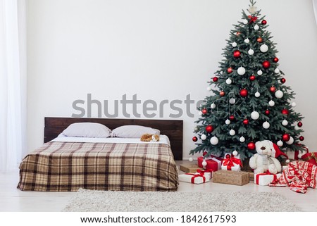 Christmas tree with gifts in the bedroom by the bed New Year