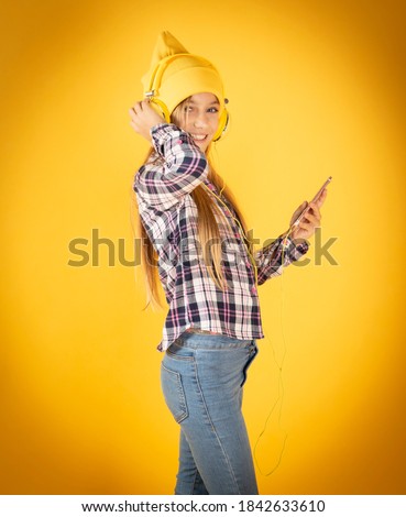 blonde girl with hat and headphones listening to music yellow