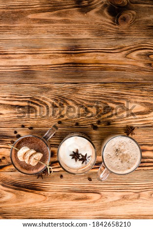 Hot chocolate on rustic wooden background, top view of set of hot drinks on a wooden table, cocoa, hot chocolate and Glasse coffee with copy space background