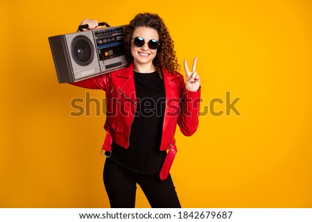 Photo of positive redhair girl hold boombox make v-sign wear jacket trousers isolated on bright shine color background