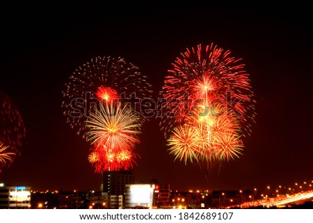 Background of Beautiful Fireworks light up the sky with dazzling display over the cityscape. Celebration and anniversary concept.