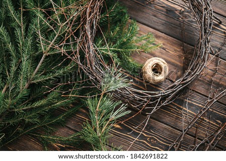 Blank for a Christmas wreath. Fresh fir branches on a wooden table. ball of twine. Selective focus and blurred background