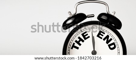 The end wording inside alarm clock with white background and copy space.