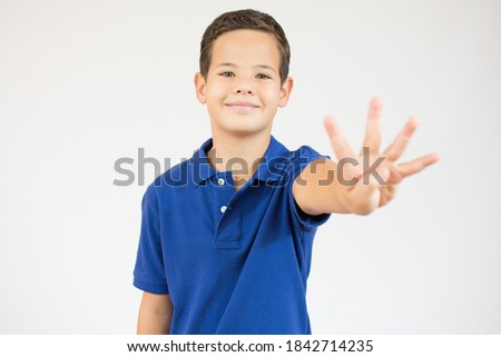 Young little boy kid wearing casual blue t-shirt standing over isolated background showing and pointing up with fingers number four while smiling confident and happy.