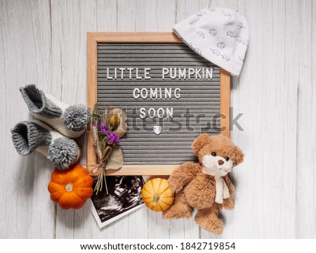 Little pumpkin coming soon sign. Baby announcement sign on a rustic white background. Coming soon concept.  Autumn pregnancy.