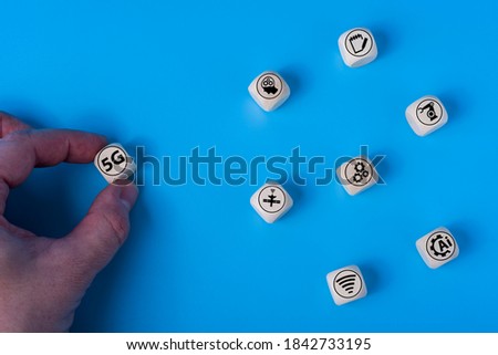Concept of 5G with icons on wooden cubes. Blue background. The concept of technologies of the future.