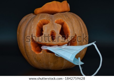 halloween pumpkin eating medical face mask. pumpkin wearing a face mask for protection from coronavirus. Halloween 2020 concept. funny pumpkin