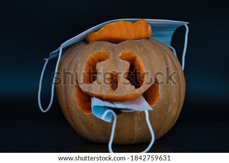 halloween pumpkin eating medical face mask. pumpkin wearing a face mask for protection from coronavirus. Halloween 2020 concept. funny pumpkin