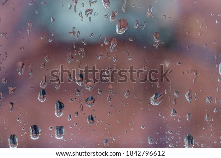 Raindrop on window in cloudy and rainy day, Water drop on glass with blurred background, Condensed, Nature water pattern texture.