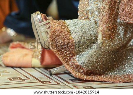 Pakistani Indian Desi bride showing her bridal shoe on her wedding day