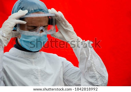 A doctor takes off his glasses after a hard day at a hospital with coronavirus patients. Tired doctor at the end of a working day in the red zone during the coronavirus pandemic