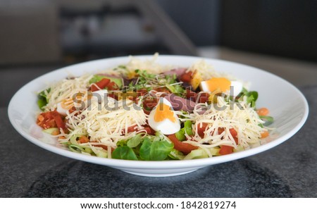 Mixed organic salad plate with tomatoes, eggs, ham and croutons, product picture