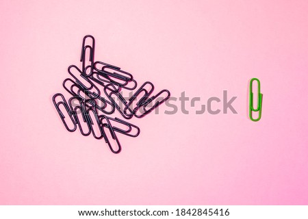 a handful of black paper clips and one green one.