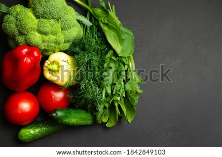 vegetables on a gray background. Cucumber tomatoes, greens and broccoli. Free space for text