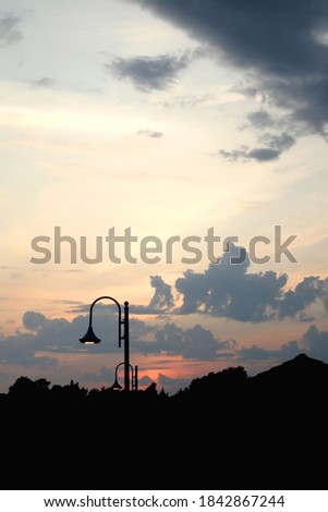 Street lamp and beautiful sunset with cloudy sky. Selective focus.