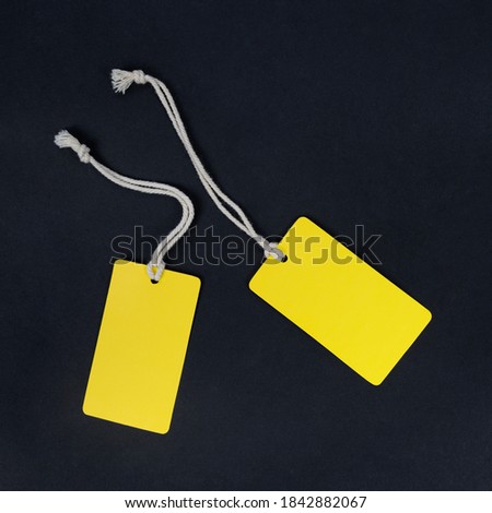 Two yellow fashion label tag mockup isolated on black.