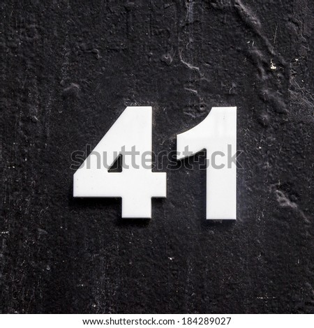 plastic house number forty one on a black painted panel