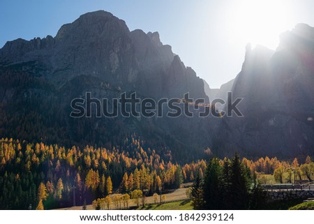 LENS FLARE: Bright autumn sunbeams shine on the rocky peaks of the Dolomites. Spectacular view of a majestic mountain range in the Italian Alps on a sunny fall day. Picturesque mountainous landscape.