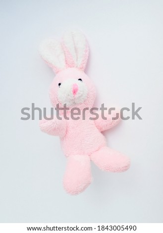 pink rabbit soft toy on a light solid background