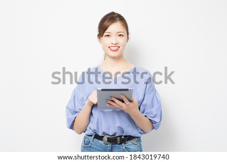 A young woman using a tablet device shot in the studio