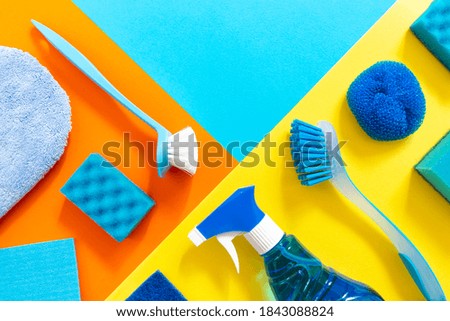 Blue set of cleaning tools on the colorfut backgrounds with geometric copy space. Clean up and spring-cleaning concept.