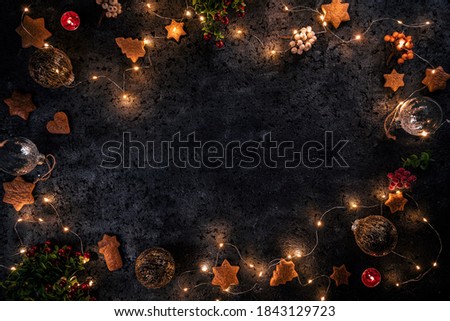 Christmas frame with gingerbreads, lights and berries, flat lay, copy space