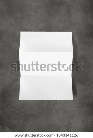 Blank folded White A4 paper sheet mockup template isolated on dark concrete background