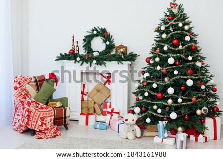Christmas tree with gifts by the fireplace for the new year decor of the house 2021 2022