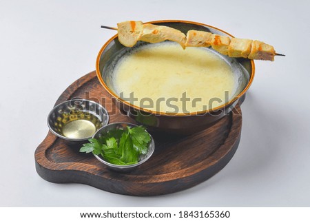 A picture of a bowl of traditional chicken soup served in a bowl over white background. Vegetable soup in a ceramic bowl.