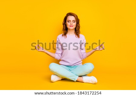 Full body photo of focused girl sit legs crossed train yoga exercise show omg symbol mediate with closed eyes wear turquoise clothing sneakers isolated over shine color background