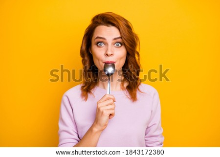Portrait of astonished inspired girl have weekend in restaurant taste dish enjoy lick spoon impressed stare stupor wear pink jumper isolated over yellow color background Royalty-Free Stock Photo #1843172380