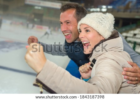 Couple cheering on their ice hockey team