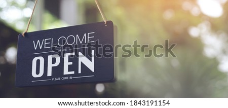 Welcome open sign on shop door. Text on cafe front or restaurant hang on door at entrance. vintage tone style. banner.
